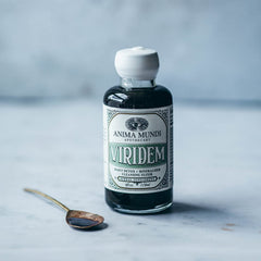 Elixir poured into juice, showing vibrant green color and texture.