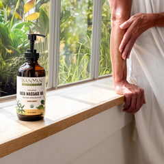 Hands applying Banyan Botanicals Vata Massage Oil during a relaxing routine.