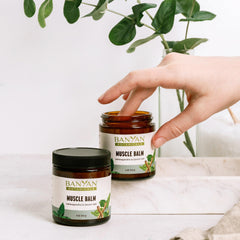 Banyan Botanicals Muscle Balm being massaged into hands for soothing relief