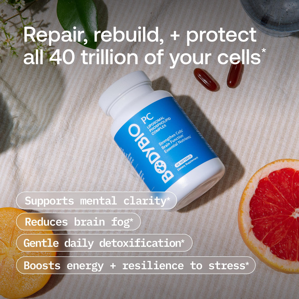 Person taking a BodyBio PC capsule with water for daily cognitive focus.