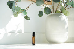 doTERRA Vetiver Touch bottle pictured beside a cozy bedside setup.
