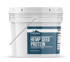 Pouring Earthborn Elements hemp seed protein into a smoothie glass