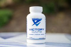 Athlete holding Victory Caps bottle during training for sustained endurance.