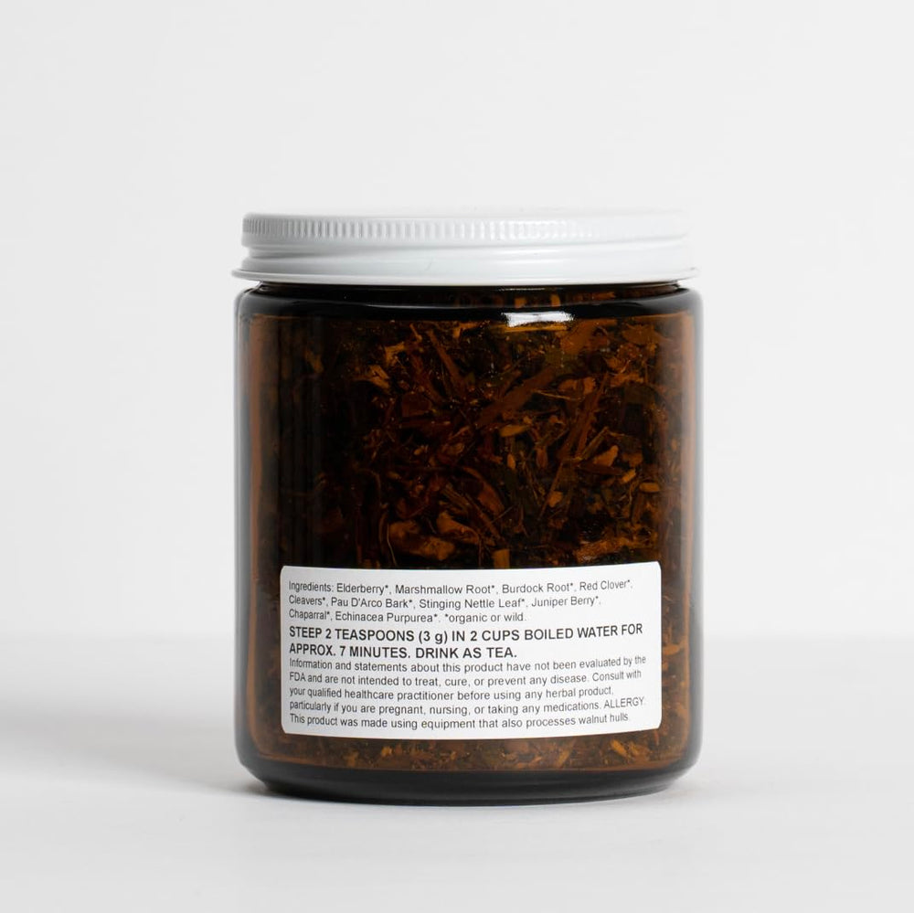 Food Over Drugs detox tea herbs close-up showing elderberry, burdock, and nettle.
