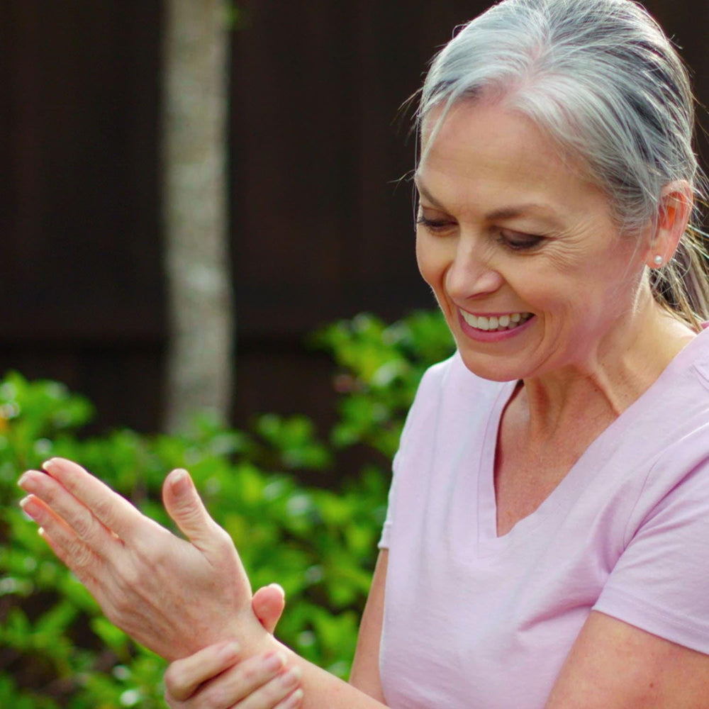 Hands massaging Gel into arthritic joints during daily routine.