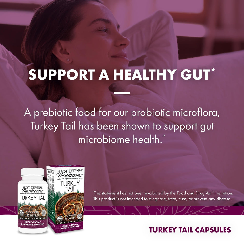 Host Defense Turkey Tail capsules beside glass of water for daily use.