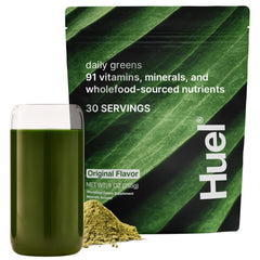 Huel Daily Greens tub and glass ready for a nutritious morning routine.