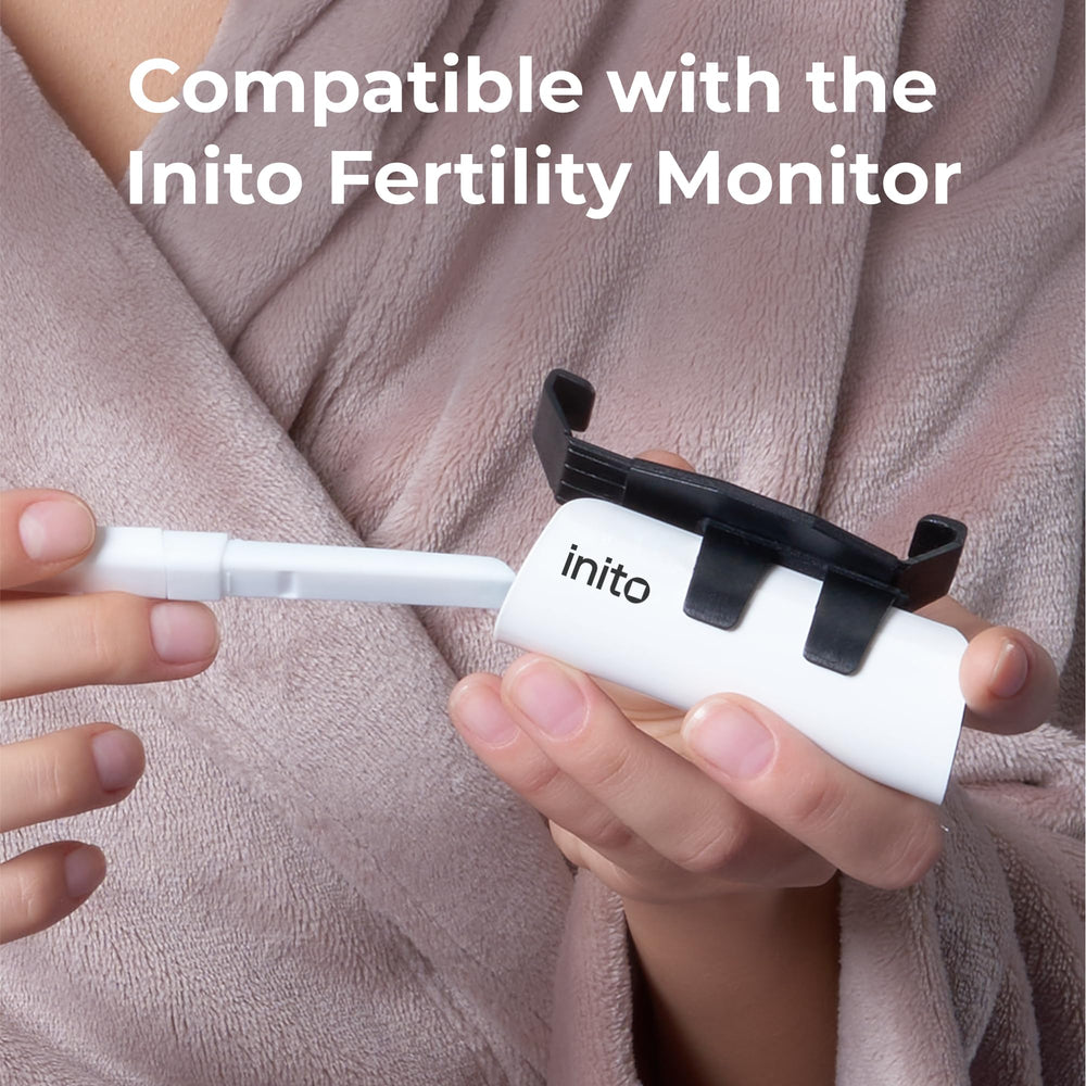 Inito test strip dipped into urine for quick at-home fertility insights.