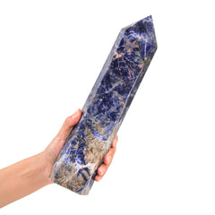 JIC Gem blue sodalite crystal wand on wood surface ideal for meditation and energy work.