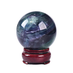 JIC Gem colorful fluorite sphere on a wooden stand for meditation and focus.