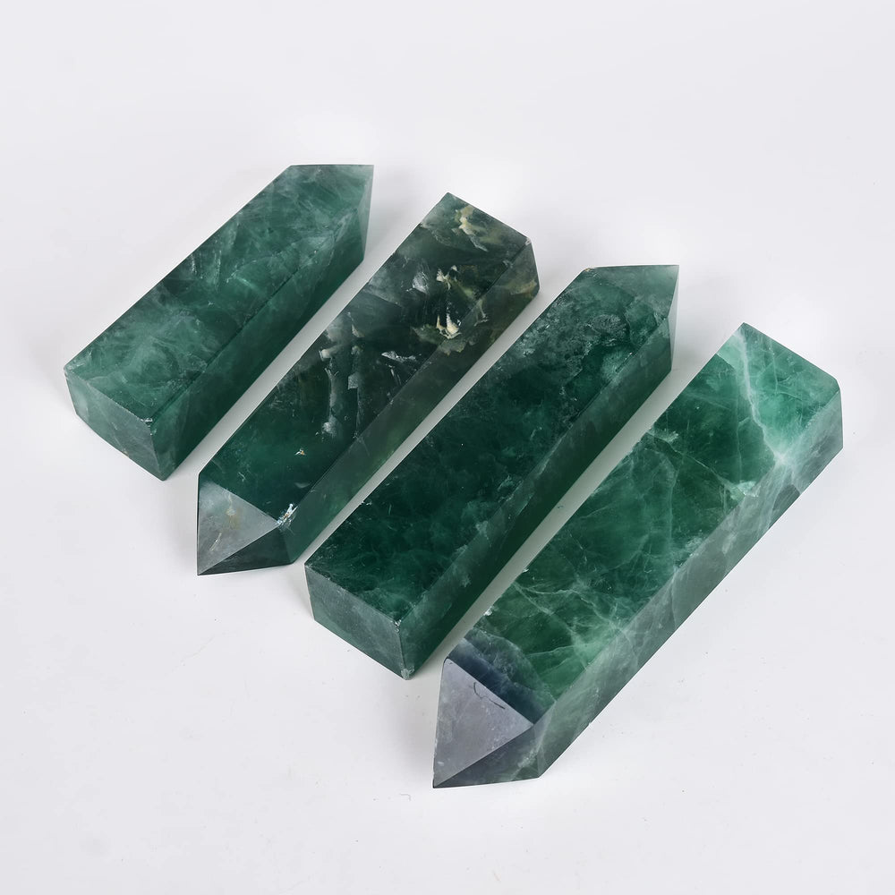 JIC Gem Green Fluorite obelisk tower displayed with a grid and candles