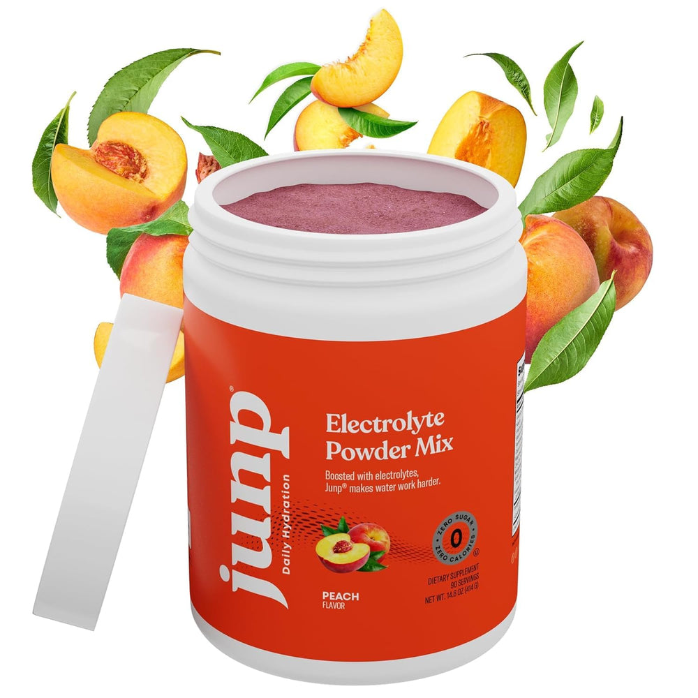 Scoop pouring JUNP peach powder into a glass for refreshing hydration.