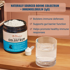 Live Conscious Colostrum powder scoop beside water for easy daily mix.