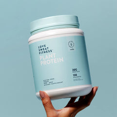 Pouring Love Sweat Fitness vanilla protein into a shaker bottle.