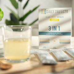 Lovie Style pineapple electrolyte packets shown beside glass of water