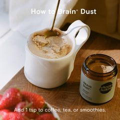 Moon Juice Brain Dust packaging beside a meditation setup for mental stamina.