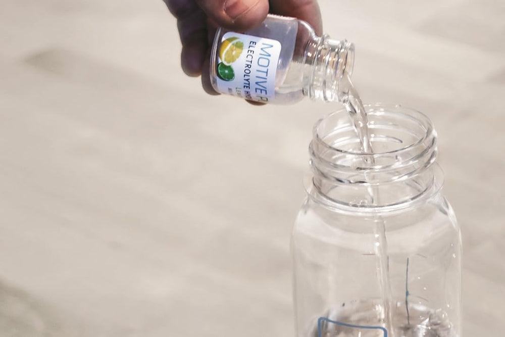 MOTIVE PURE pink lemonade electrolyte being poured into a glass