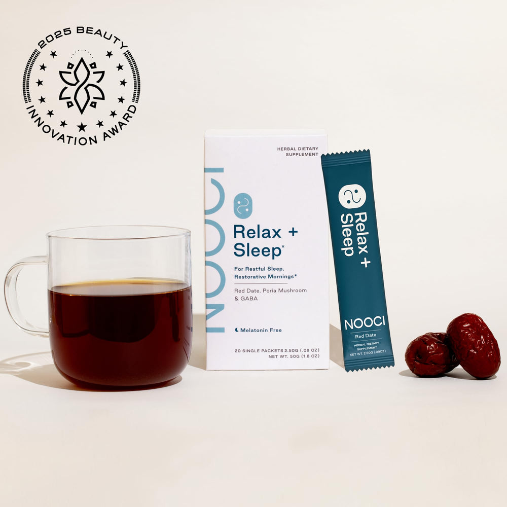 Cozy night setup with NOOCI Relax + Sleep sachet beside a warm mug.