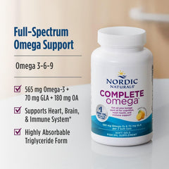 Nordic Naturals Complete Omega lemon softgels beside a glass of water for easy swallowing.