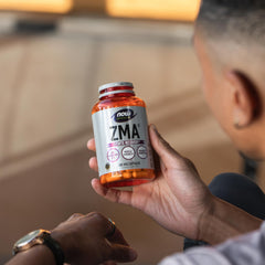 NOW Foods ZMA capsules paired with a glass of water for easy swallowing