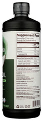 Nutiva MCT Oil on the kitchen counter beside a bottle and cup.