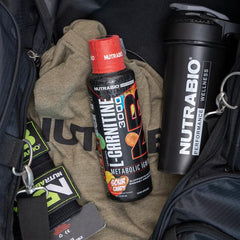 NutraBio L-Carnitine bottle glass close-up highlights sour candy flavor.