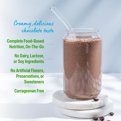 Close-up of Orgain ingredients blend with greens and fruits in view.