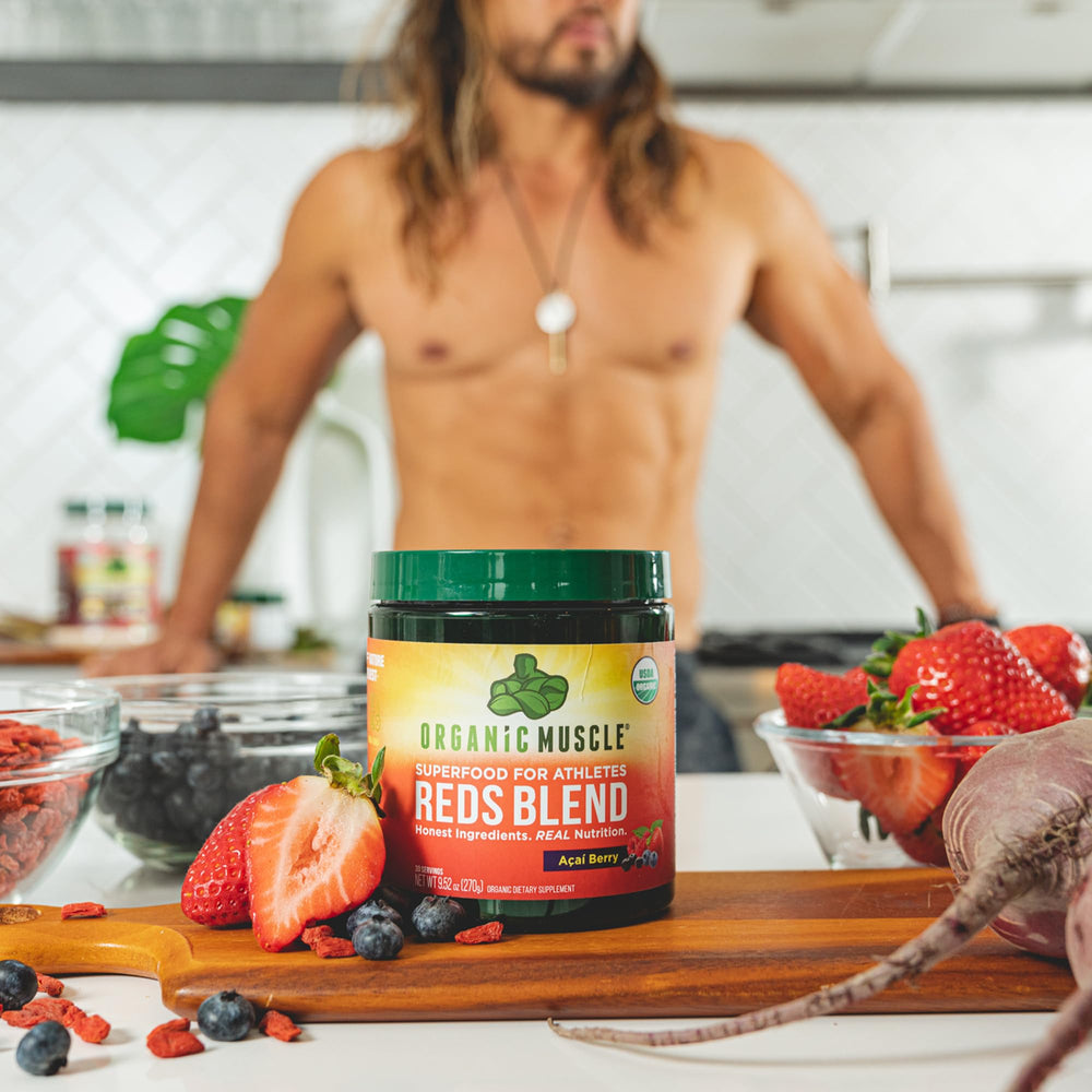 Smoothie bowl blending Organic Muscle Reds Powder into a vibrant red drink.