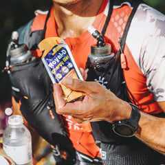 Person tearing open a Royal-D orange gel sachet for instant energy.