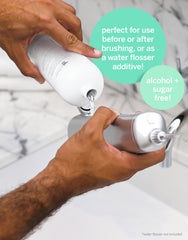 Bathroom use scene with Supersmile pre-rinse in hand