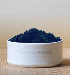 Terrasoul chlorella powder poured into a glass for quick mixing.