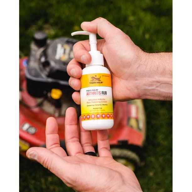 Applying Tiger Balm Arthritis Rub to an elbow demonstrates massage-friendly relief.