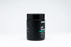 VShred MD NR Boost capsules resting with a glass of water, signaling daily wellness support.