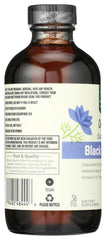 Whole Foods Market black seed oil spill on wood surface suggests culinary or wellness use