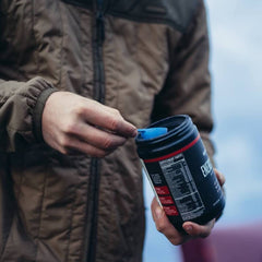 Wilderness Athlete Energy Mango Bango powder being mixed in water.