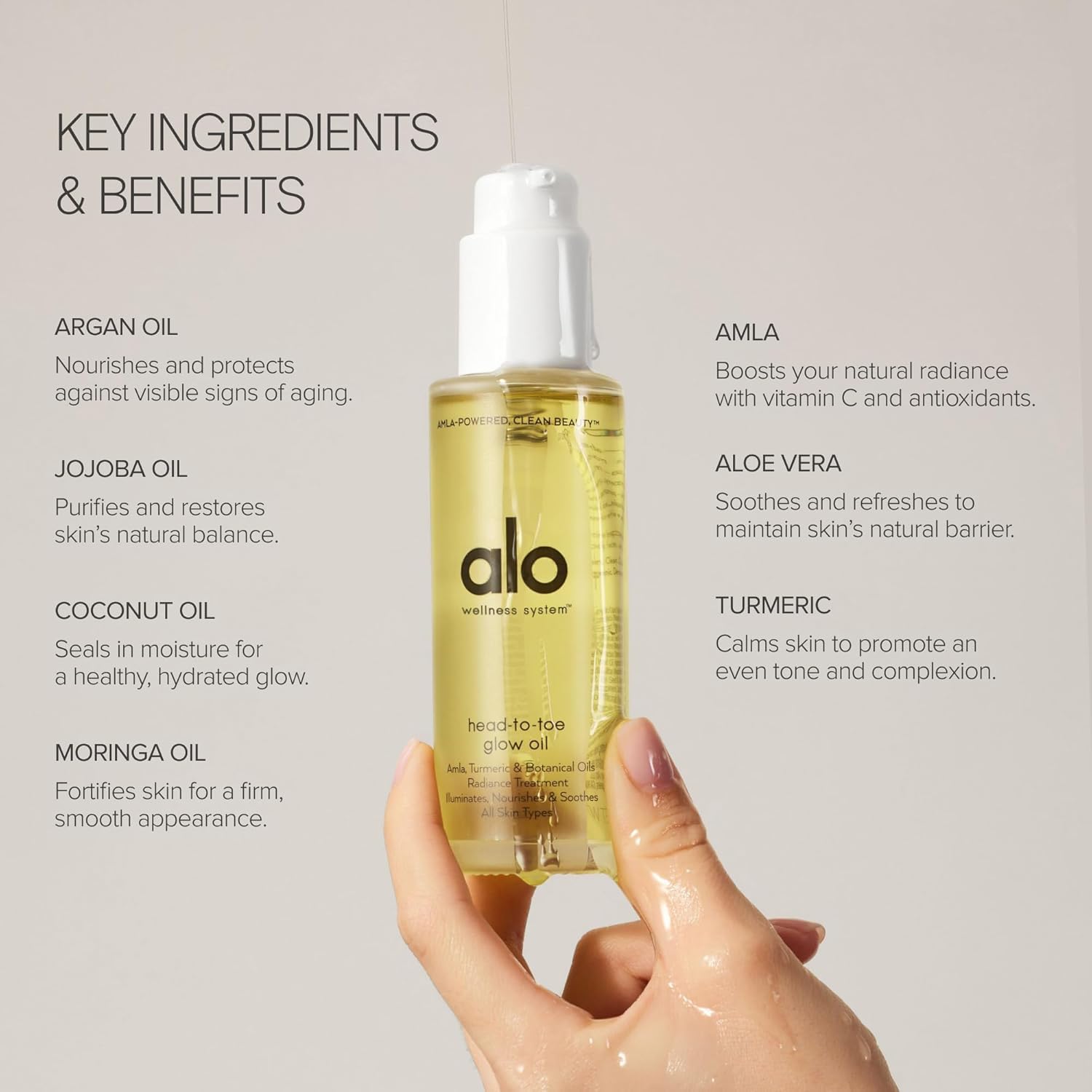 Alo Head-to-Toe Glow Oil bottle with visible golden droplets for luminous skin.