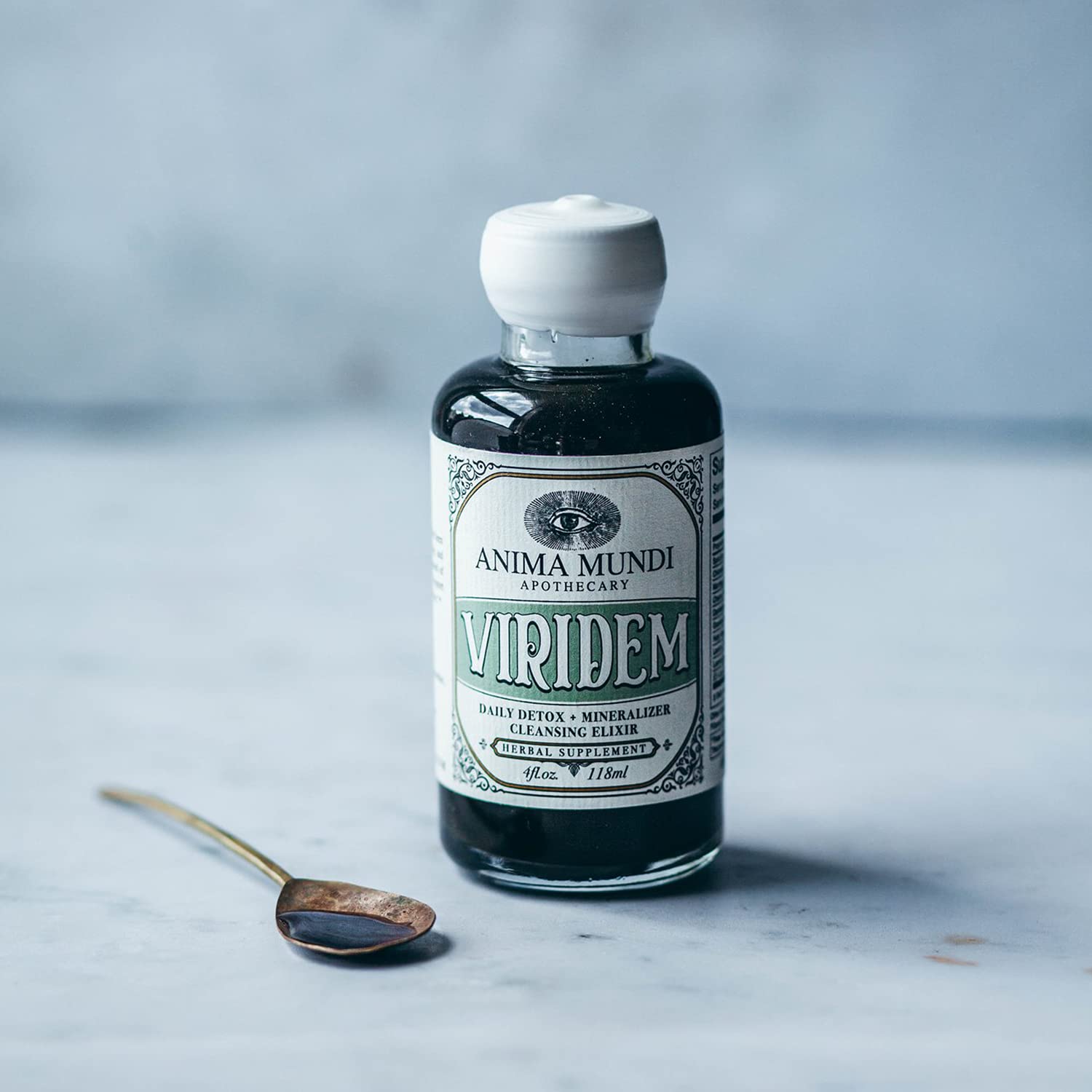 Elixir poured into juice, showing vibrant green color and texture.