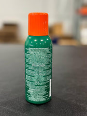Hands applying AVON Bug Guard Expedition spray during a hike to repel pests.