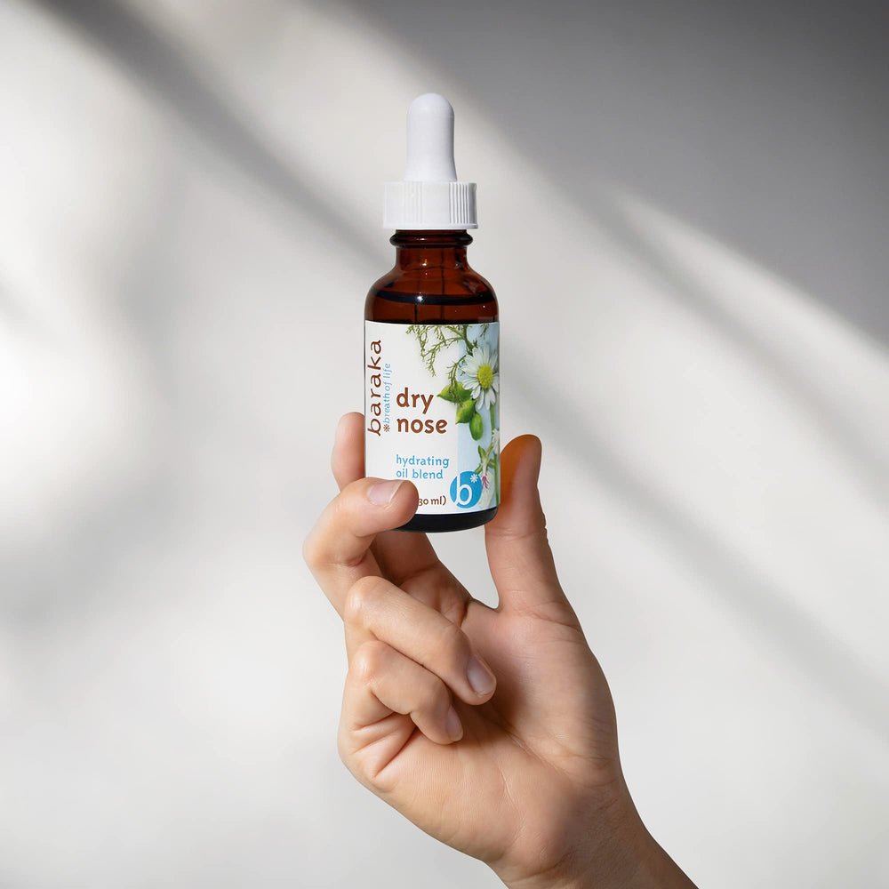 Baraka Dry Nose Nasal Oil ingredients scene with cardamom and chamomile.