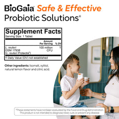 BioGaia probiotic chewable bottle with family in kitchen suggesting daily habit.