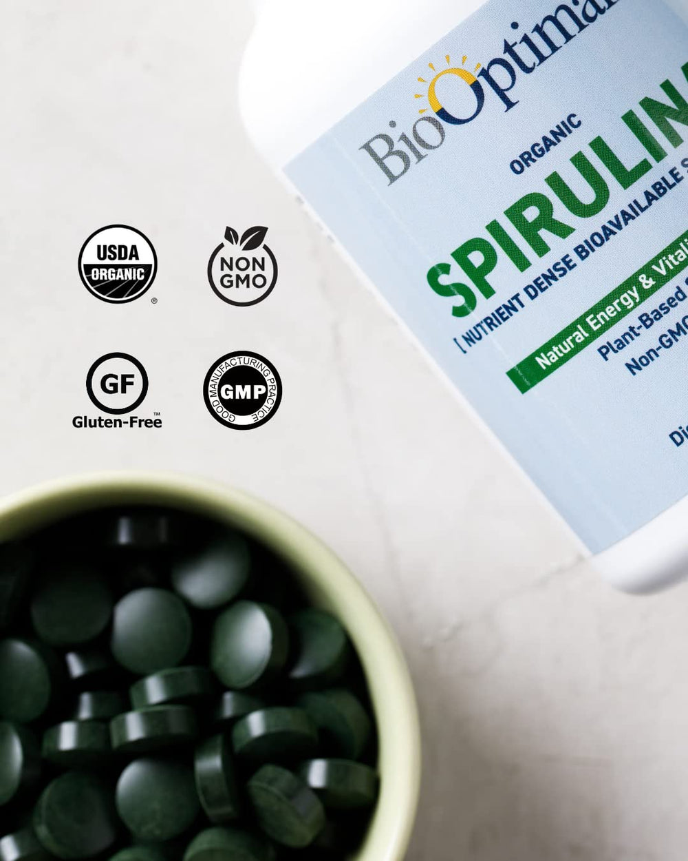 BioOptimal spirulina tablets in-use glass, convenient daily dose.