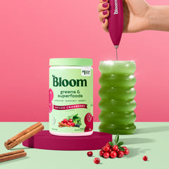 Bloom Nutrition greens powder being poured into a shake for easy daily integration