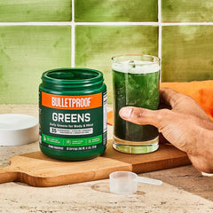 Bulletproof Greens scoop beside a glass illustrating a simple daily serving