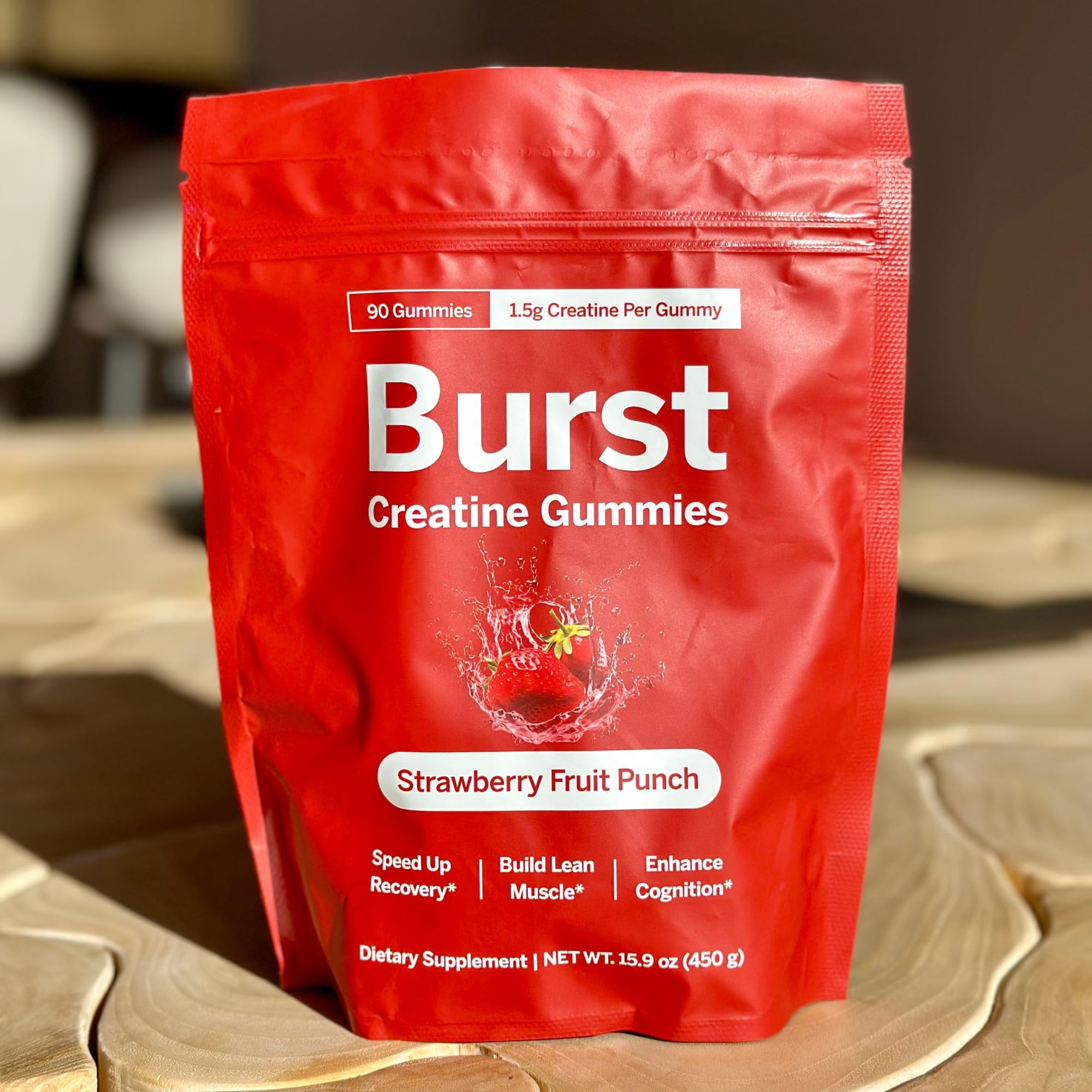 Strawberry pieces nearby Burst Creatine Gummies to evoke flavor and aroma.