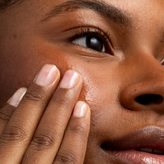 Close-up of Cliganic Apricot Oil amber bottle highlighting purity and natural texture.