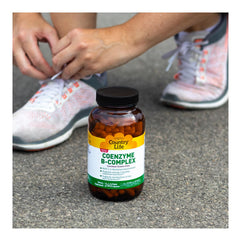 Pouring Country Life Coenzyme B-Complex bottle with tasteless capsules.