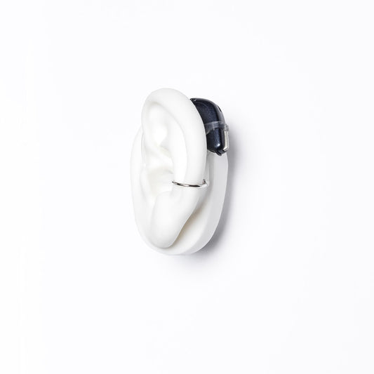 Deafmetal silicone holster on the ear provides universal attachment for behind-the-ear devices.