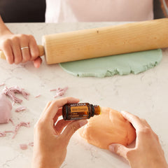 doTERRA Wild Orange bottle beside skincare base for DIY body oil.