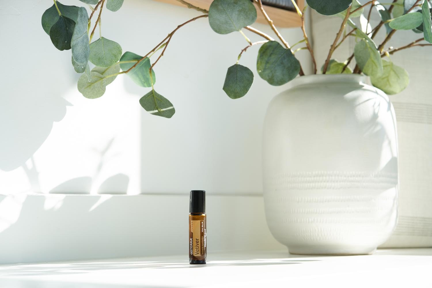 doTERRA Vetiver Touch bottle pictured beside a cozy bedside setup.