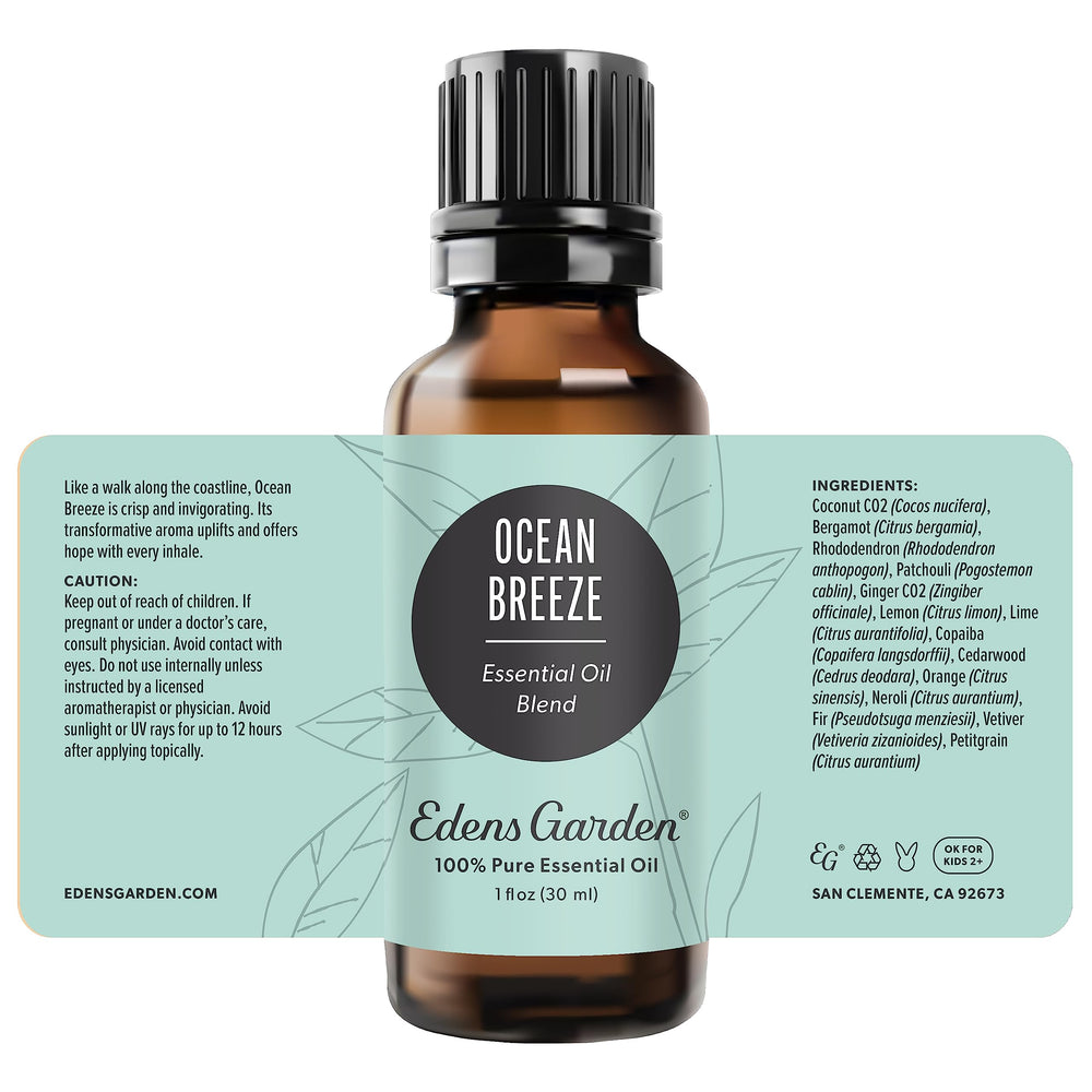 Edens Garden Ocean Breeze oil bottle beside candle for ambiance